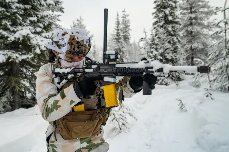 A French soldier defends his position while moving through deep snow.